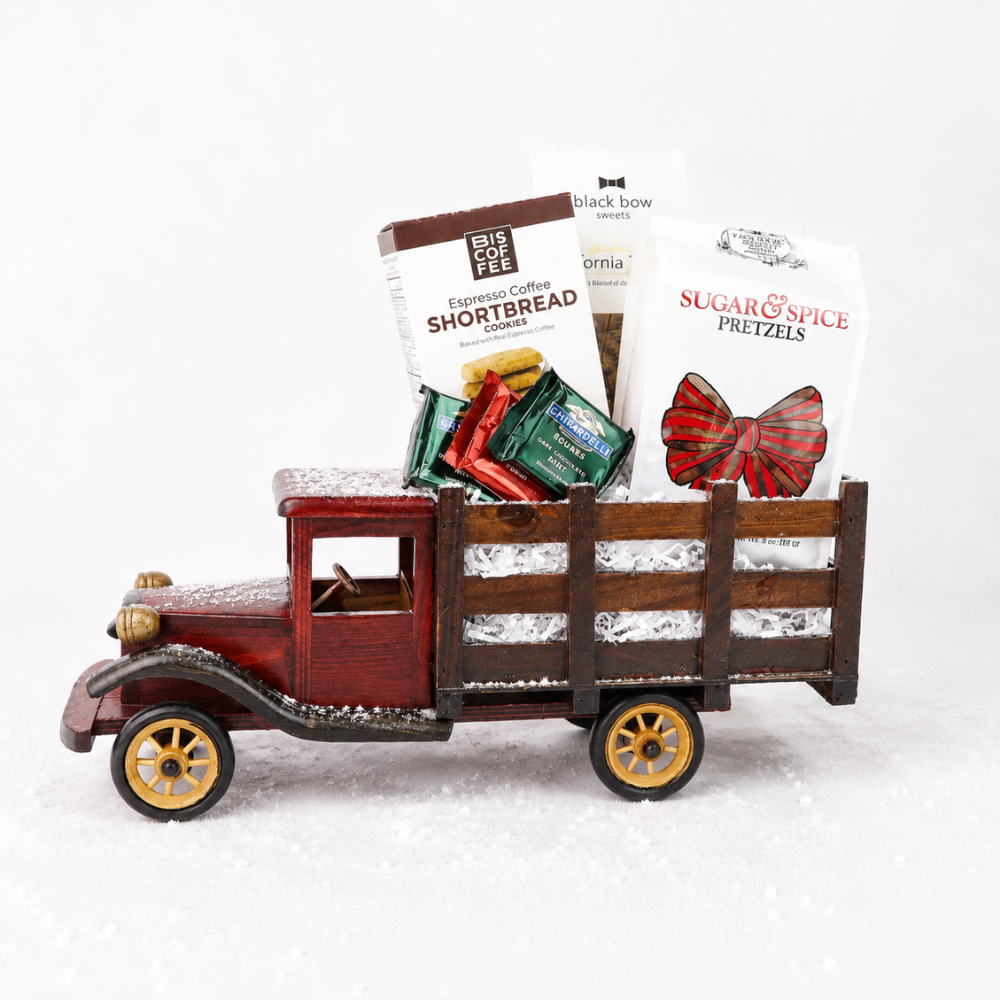 A vintage-style red toy truck with gold wheels and a wooden slatted bed, filled with packaged snacks including bags of Big Bag Coffee and Sugar & Spice Pretzels, on a white studio background.