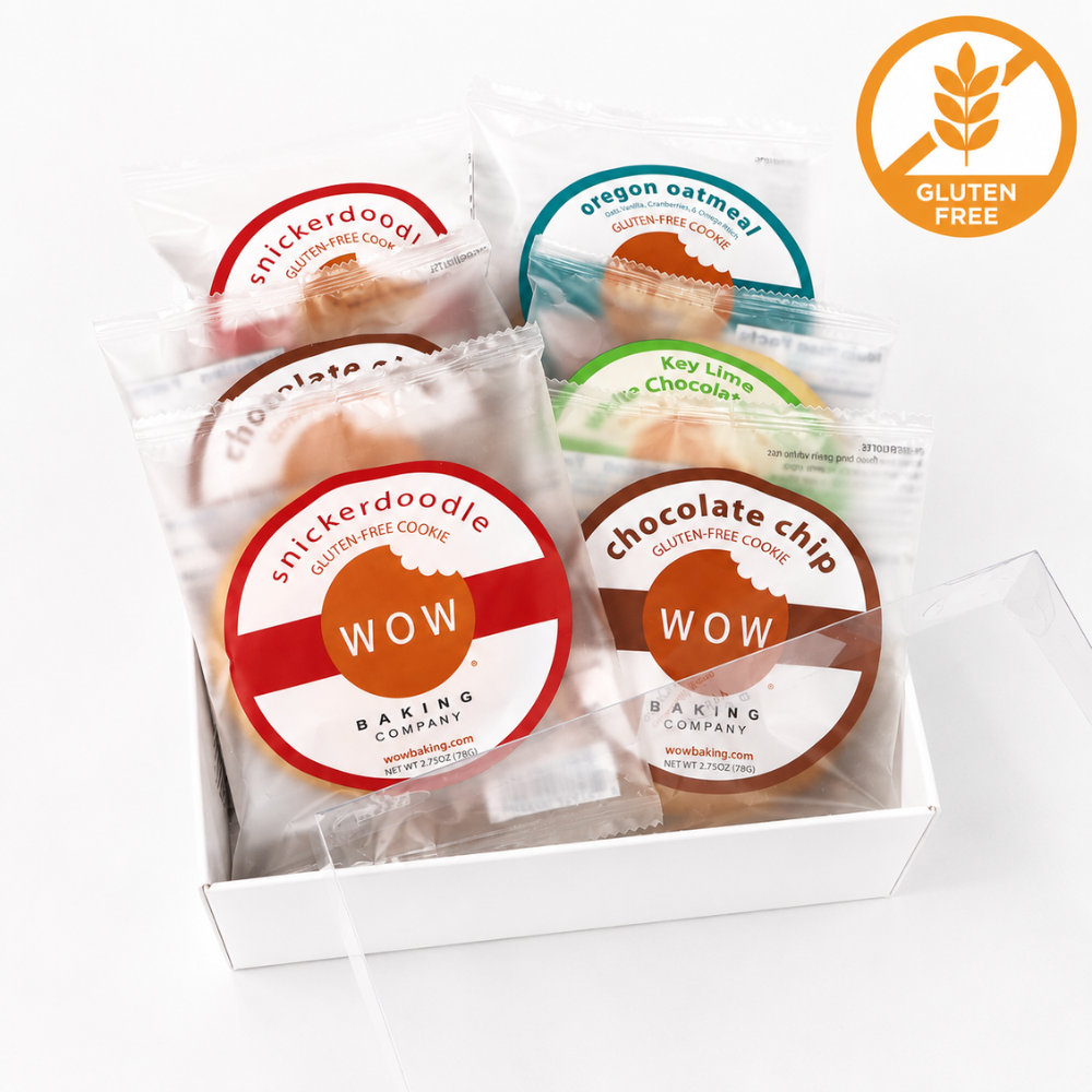 A white gift box containing several packaged gluten-free cookies from WOW Baking Company, including Snickerdoodle, Oregon Oatmeal, Key Lime Pie, and Chocolate Chip flavors. A circular gluten-free icon appears in the top right corner.
