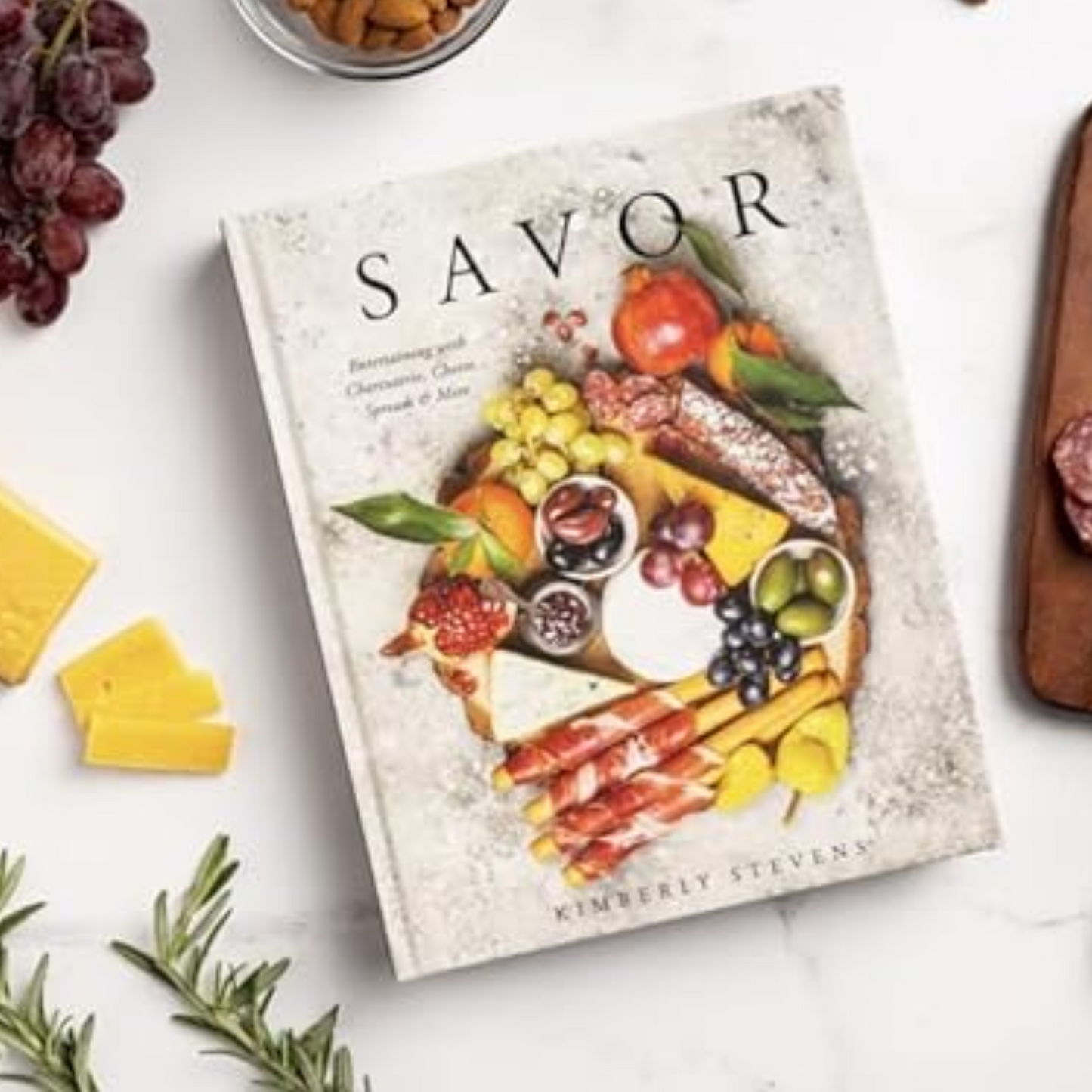Cookbook titled 'Savor' with food imagery on a white surface