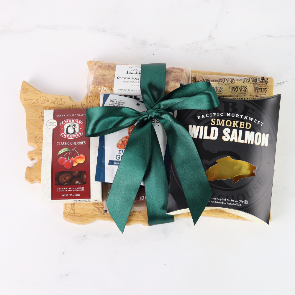 Washington Snack Board gift basket comes with a Washington state shaped bamboo cutting board, smoked salmon, cookies, crackers, chocolate caramels and candied nuts. Pacific Northwest Gift Baskets