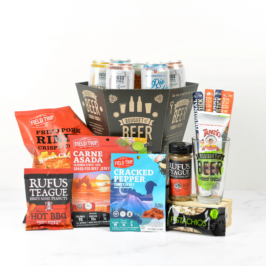 Assorted beer gift basket with  food and beverage items including chips, jerky, and drinks on a white background