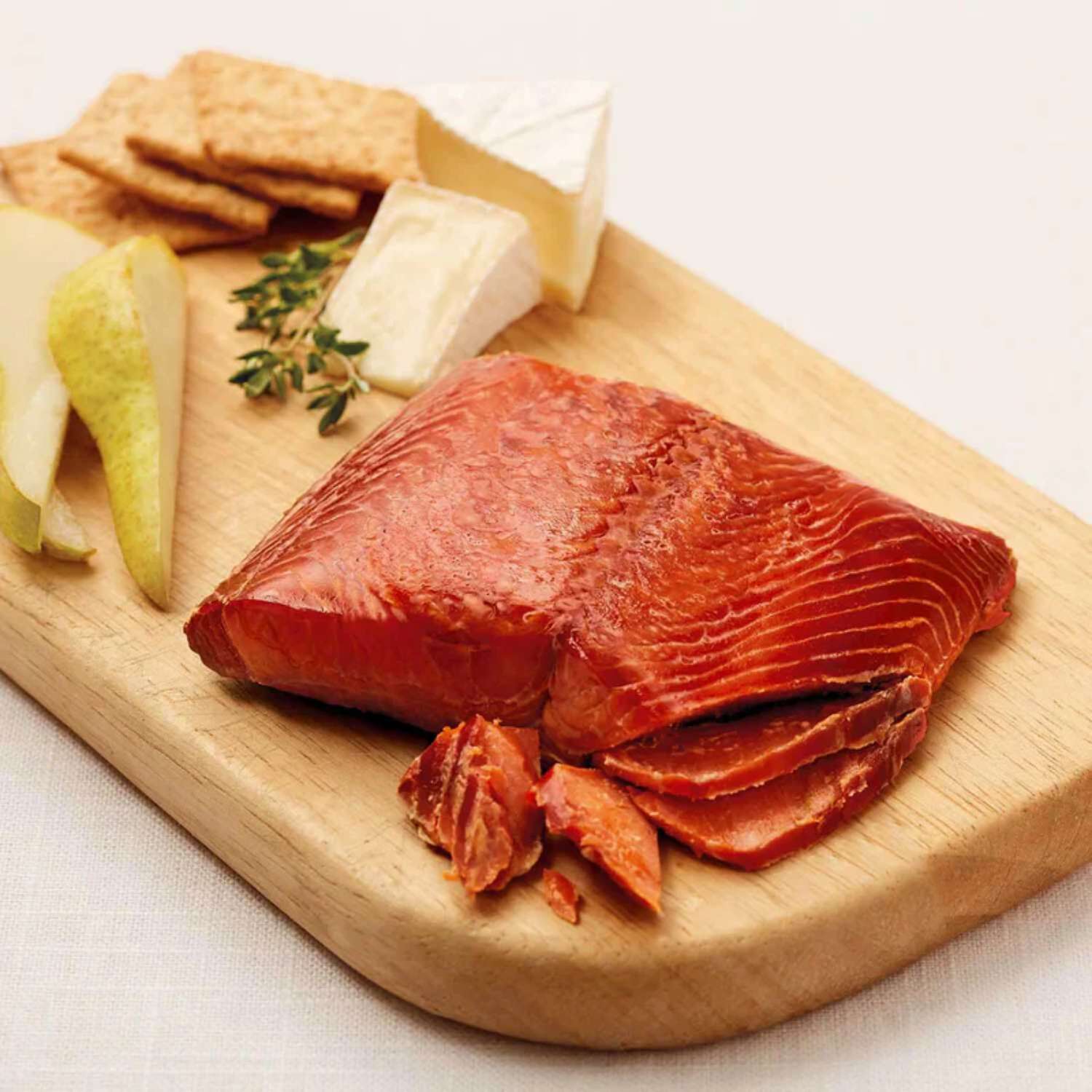 Wild Alaskan Sockeye smoked salmon fillet served on a wooden board, a signature Pacific Northwest delicacy ideal for Seattle gift baskets.