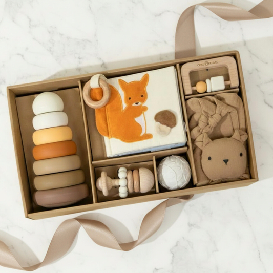 Collection of modern baby toys in a box on a white marble surface