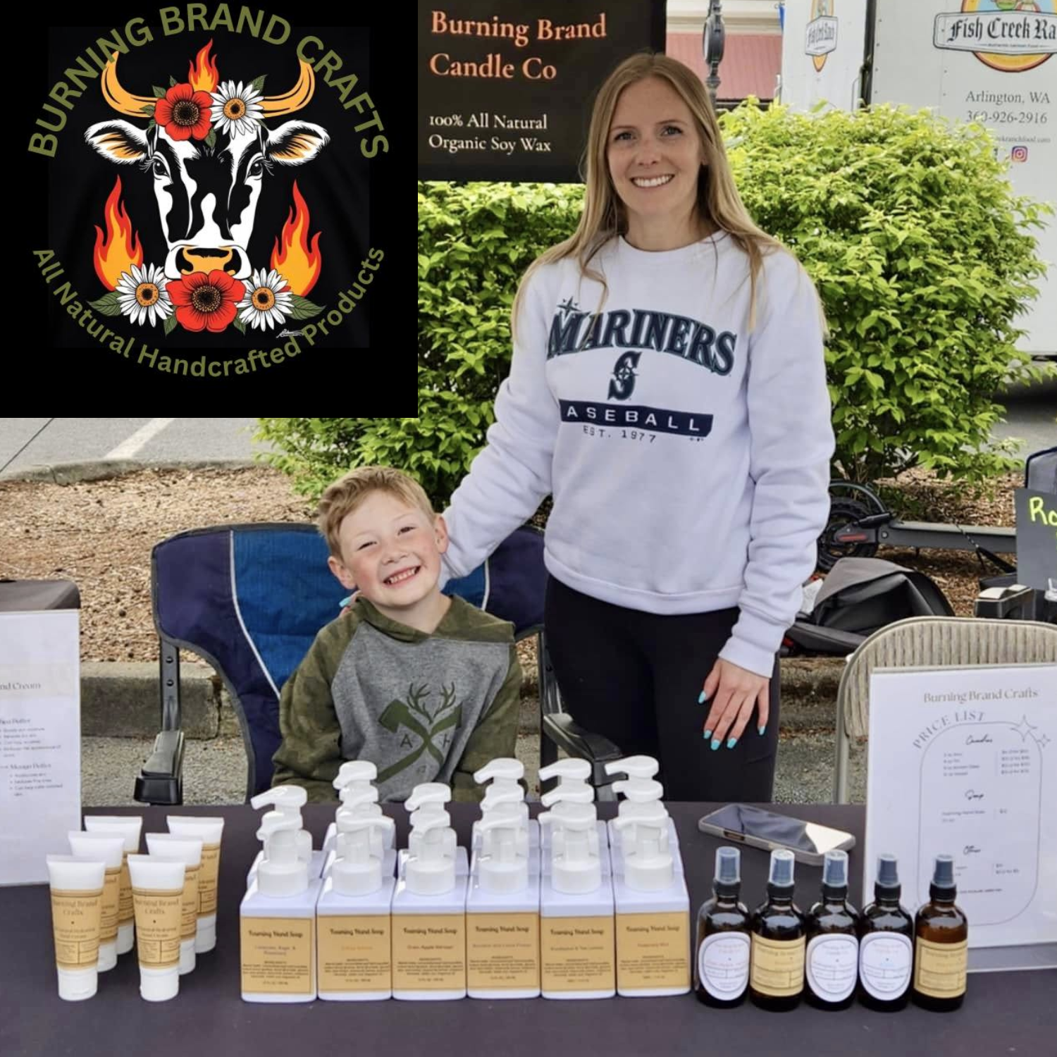 Woman and child standing behind a table with various products, including bottles and a cow logo for Burning Brand Candle Co.