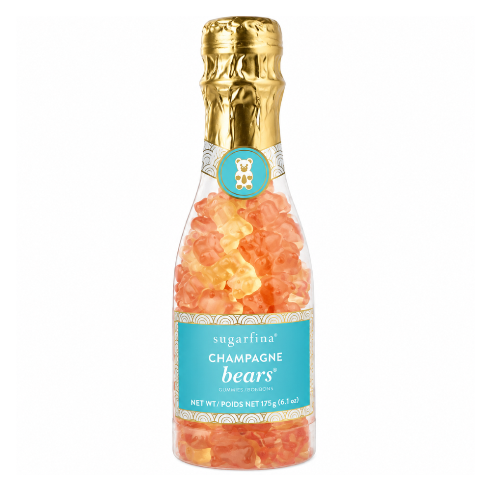 A bottle of Sugarfina Champagne Bears gummy candies, featuring orange and yellow gummy bears visible through a clear glass bottle with a gold foil neck wrap and a turquoise label.