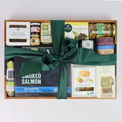 Holiday gift basket with Pacific Northwest smoked salmon, chocolates, and gourmet snacks tied with a festive green bow – perfect Christmas or corporate gift.