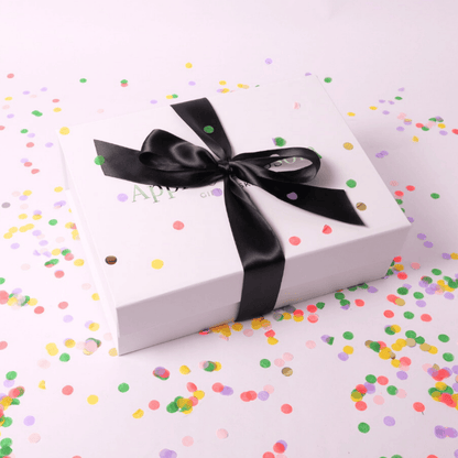 A sleek white gift box tied with a luxurious black satin bow, exuding elegance and perfect for any celebration.