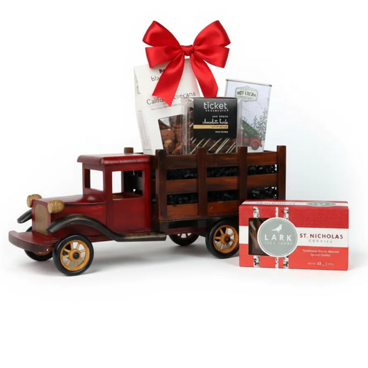 Vintage wooden truck gift basket filled with cookies and chocolates, tied with a red satin bow