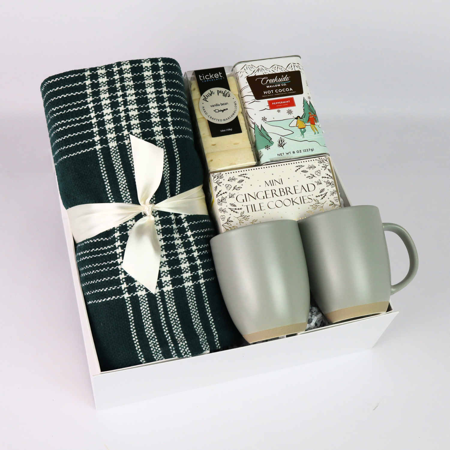 Luxurious Christmas gift box featuring a plaid throw, mugs, and festive treats, perfect for client gifts or as an elegant employee gift. Packaged in a soft-touch gift box with magnetic closure for a premium presentation.