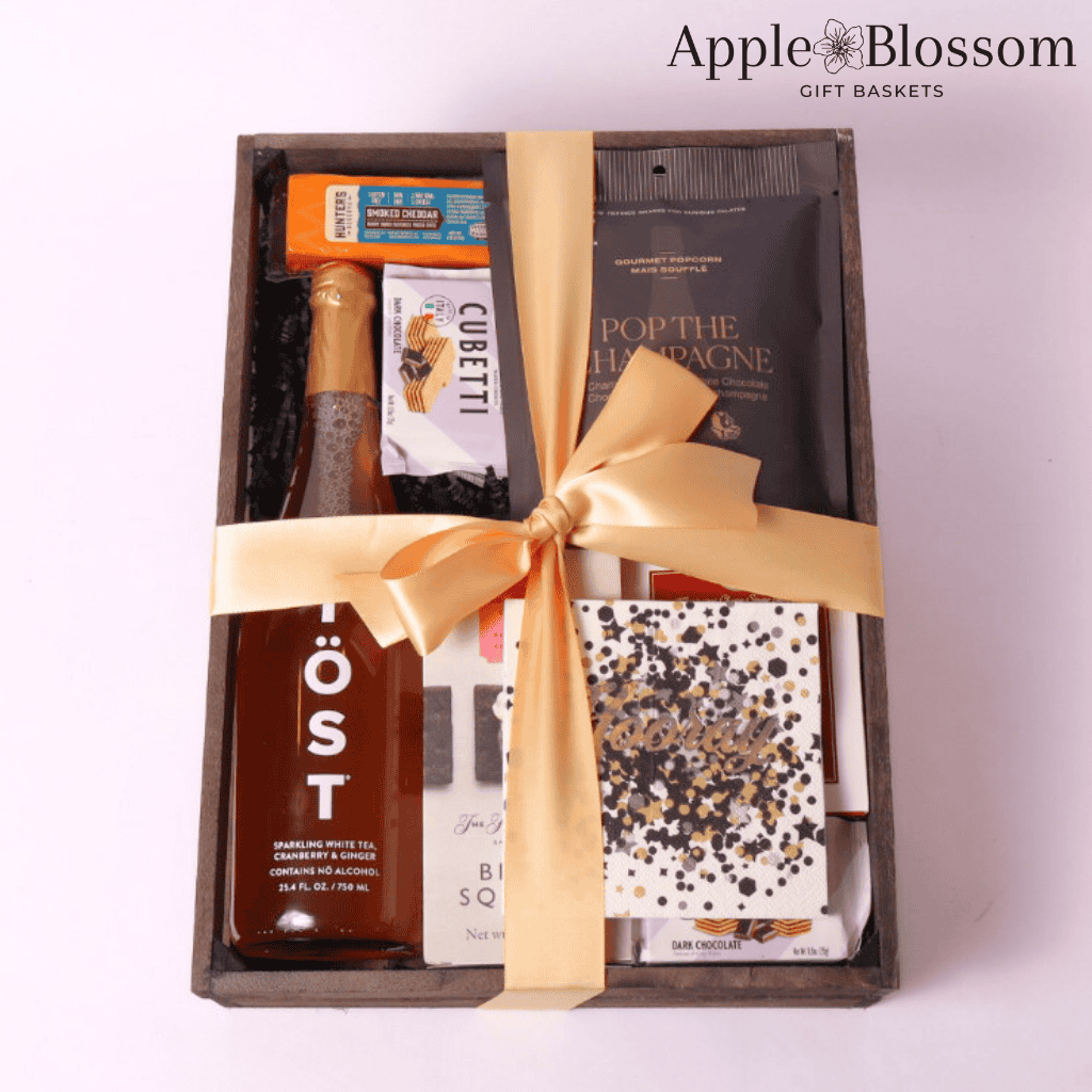 cue the confetti celebration gift basket comes in a wooden tray with cheese, crackers, white tea, wafer cookies, nuts, party popper, napkins and  infused white chocolate popcorn.  Made by Apple Blossom Gift Baskets