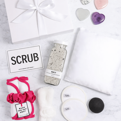 Day At The Spa Gift Basket Day At The Spa Gift Basket Day At The Spa Gift Basket Flat lay of spa gift contents featuring a pink scrunchie, SCRUB sponge card, bath salts, headband, and face cloths—highlighting customer review.