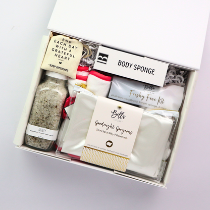 Day At The Spa Gift Basket Open spa gift set with mint bath salts, konjac sponges, gemstone heart stones, and self-care essentials neatly arranged inside a soft-touch white gift box.