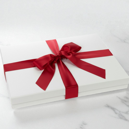 large White gift box with a red ribbon on a marble surface