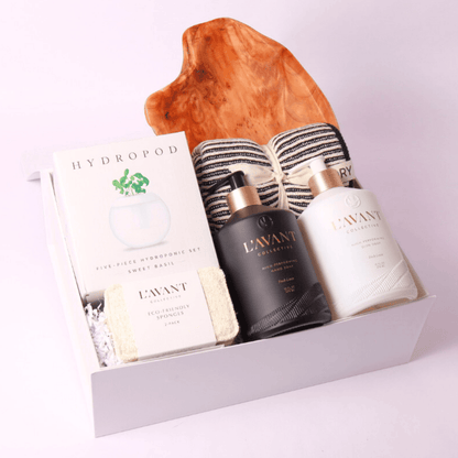 Elegant new home gift set with high-end home essentials, including plant-based soaps, premium kitchen linens, a basil hydroponic kit, and a chic wooden serving board—perfect for a stylish housewarming gift.
