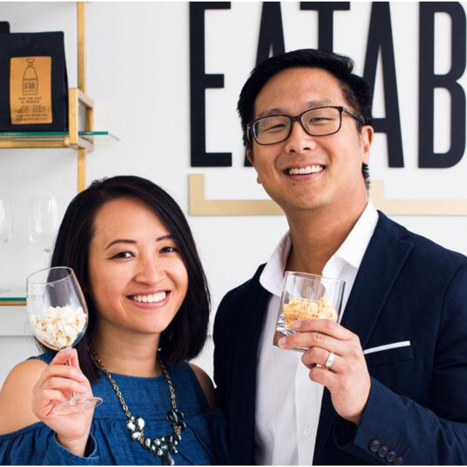 the owners of eatable popcorn standing with popcorn to cheers with in their cocktail glasses