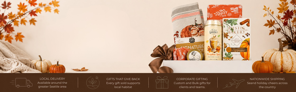 A holiday gift basket bundle featuring gourmet snacks, a can of coffee, and packaged treats, styled with autumn leaves, pumpkins, and a knitted blanket against a cream background, with a dark brown banner at the bottom containing promotional text.