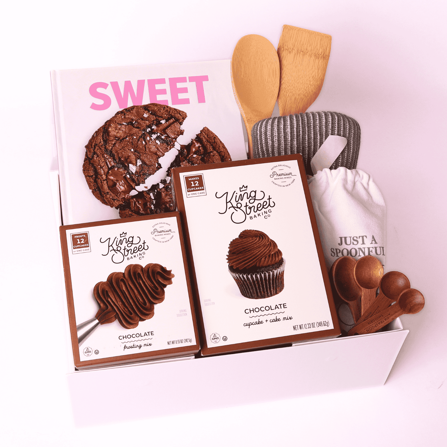 Baking gift box with mixes, towel, and utensils: Chocolate baking gift basket with cupcake and frosting mixes, spatulas, towel, and wooden spoon set.