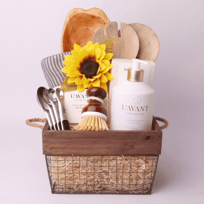 For the Kitchen Gift Basket – A beautifully curated kitchen gift basket featuring L’AVANT dish soap, eco-friendly sponges, a salad serving set, a hand-carved wooden platter, and more, elegantly arranged in a rustic wire and wood basket. Seattle housewarming  gift baskets