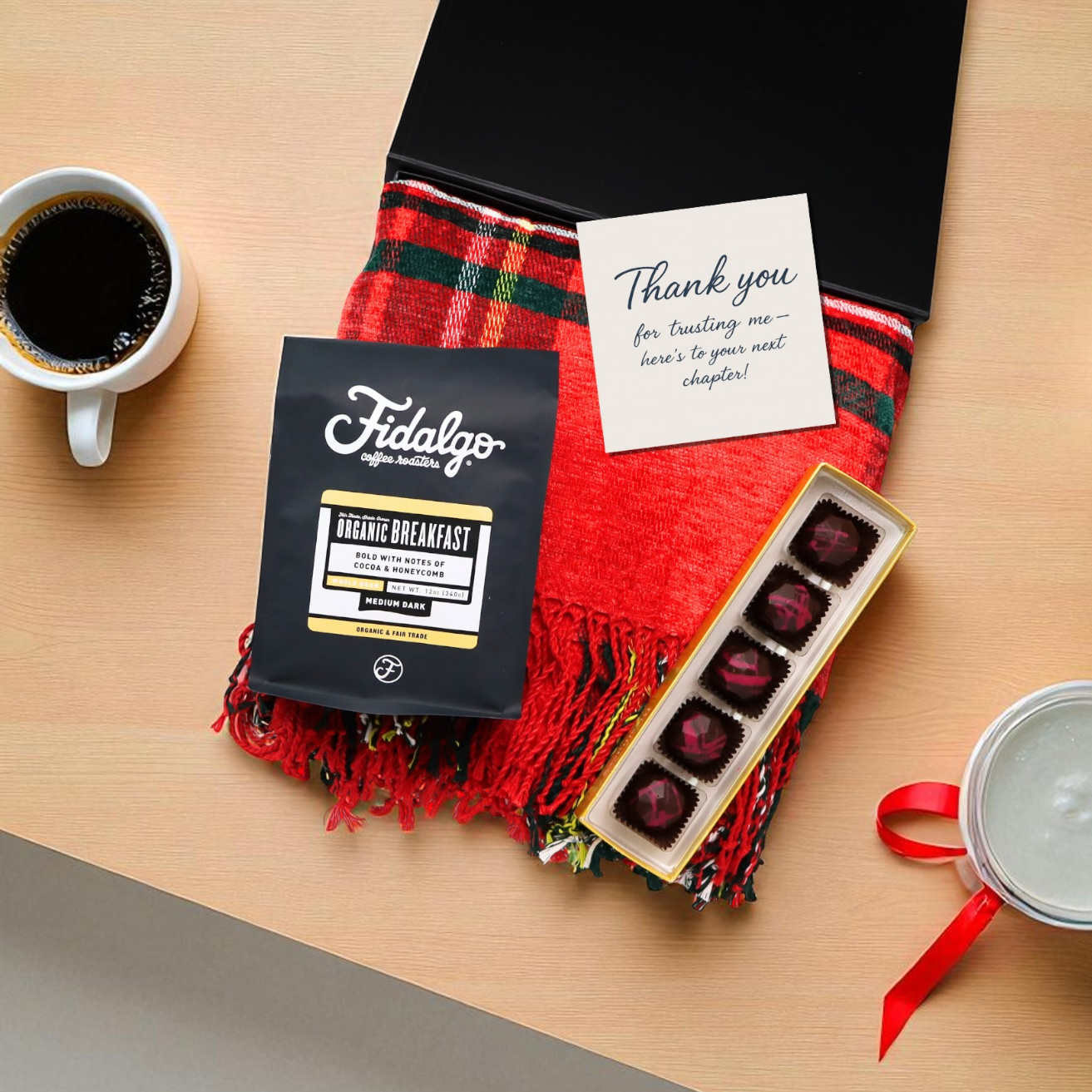 Fidalgo coffee package, red scarf, chocolate truffles, and a card on a wooden surface.