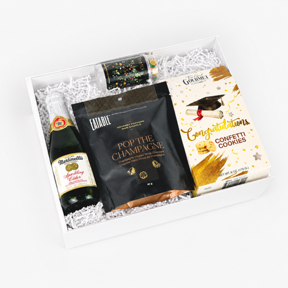 Graduation gift box with festive snacks, sparkling cider, confetti cookies, and celebration treats for a graduate