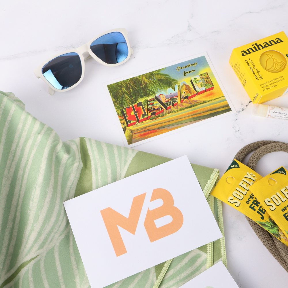 Sunglasses, postcard, and other items on a white surface