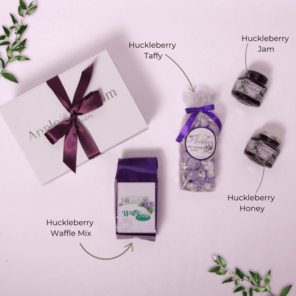 Flat Lay of Washington Huckleberry Gift Box Contents – A top-down view displaying wild huckleberry jam, saltwater taffy, and waffle mix, neatly arranged in a signature gift box for a delightful gourmet gift.
