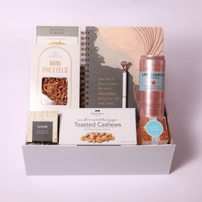 Uplifting gift box with a motivational notebook, diamond pen, champagne gummy bears, and Shine Pop Open Cards for daily inspiration and positivity.
