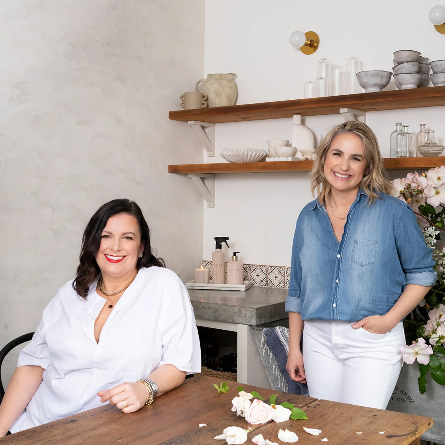Two women, the founders of lavant in a kitchen setting with shelves and decor.