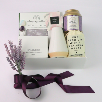 Gift set with lavender pillow, tea, and tea on a white background. Lavender gift box styled with purple satin ribbon and dried lavender, showcasing handmade laconnor bar soap