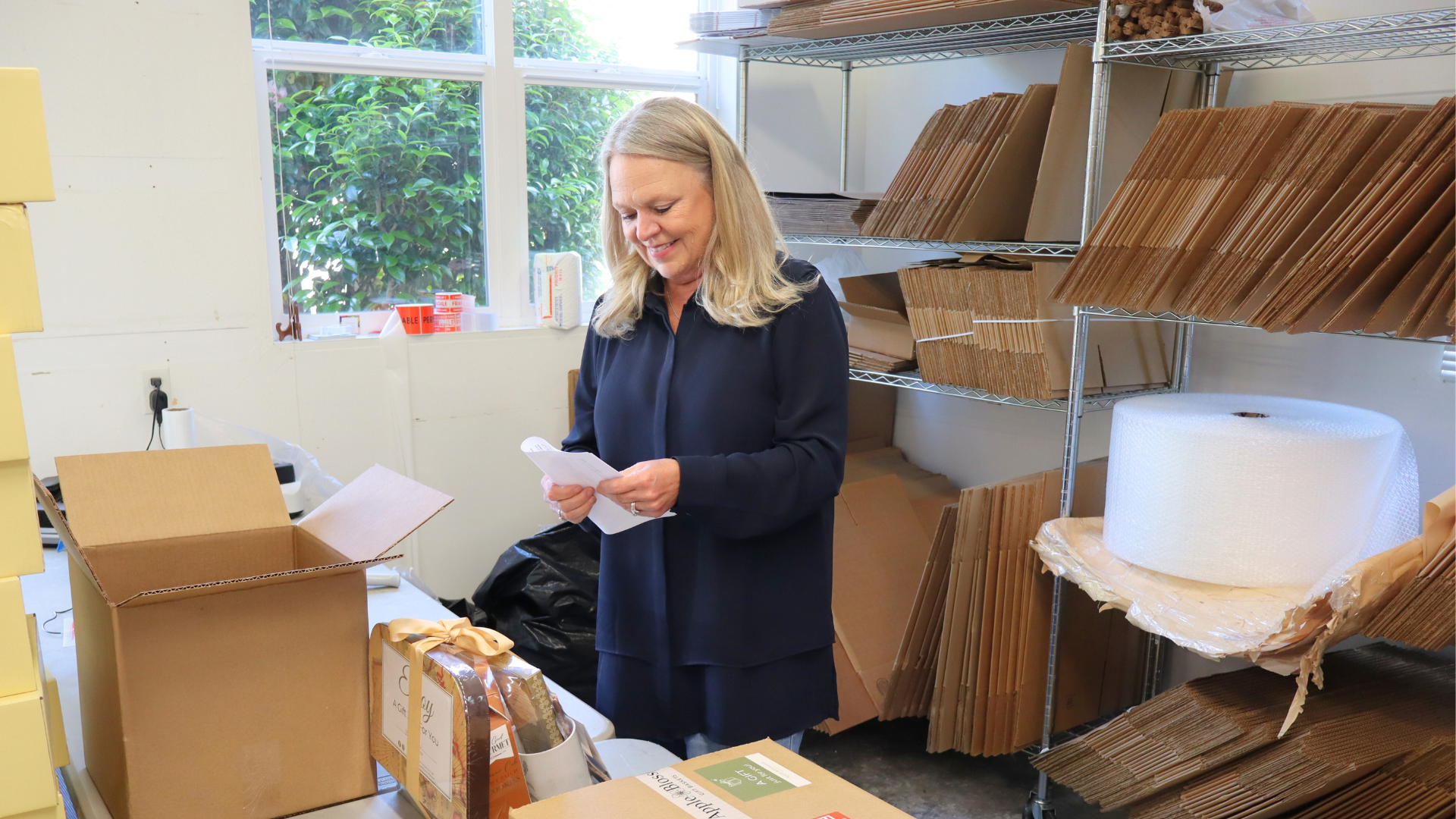 Lisa working in the shipping department boxing up corporate gifting orders to be sent out