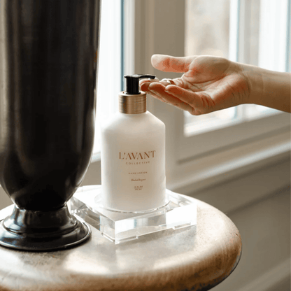 A close-up of L'AVANT Collective Blushed Bergamot Hand Lotion in an elegant glass dispenser, packed with nourishing, plant-based ingredients for a spa-like experience