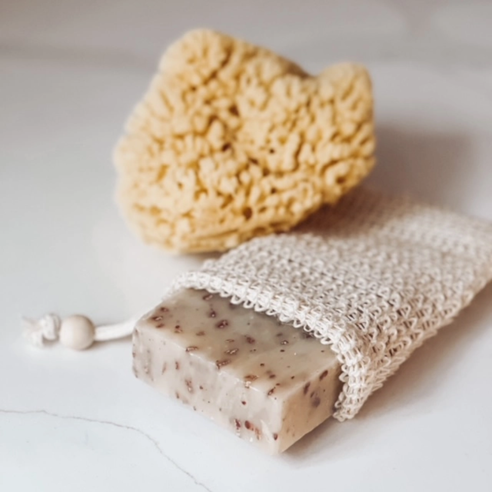Bar of soap with a loofah and a natural sponge on a light background