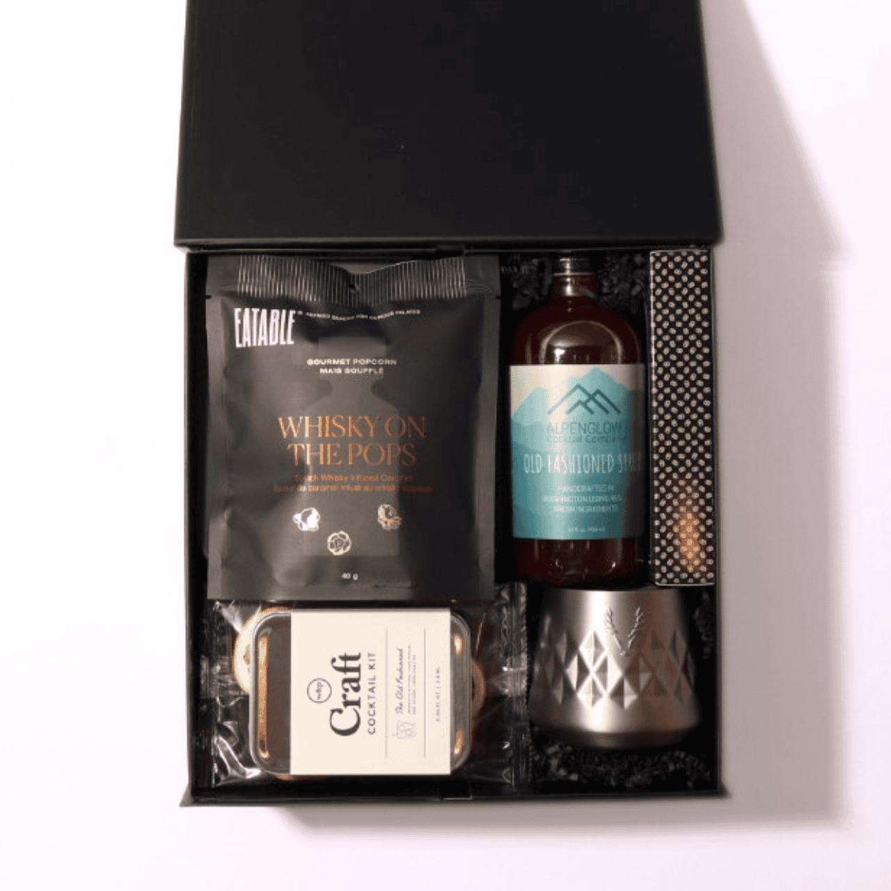 old fashioned gift set with a luxury black box, hand-tied bow, and essentials like a cocktail kit, infused popcorn, ice cube mold, and optional recipe book.