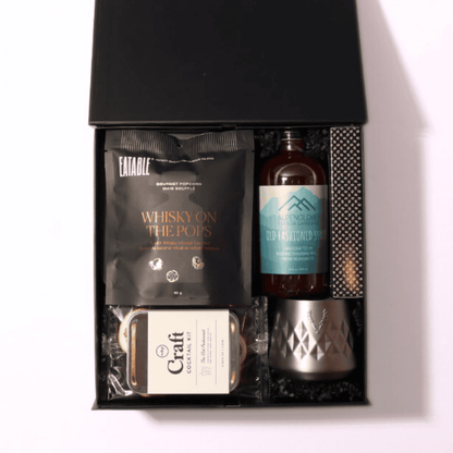 old fashioned gift set with a luxury black box, hand-tied bow, and essentials like a cocktail kit, infused popcorn, ice cube mold, and optional recipe book.