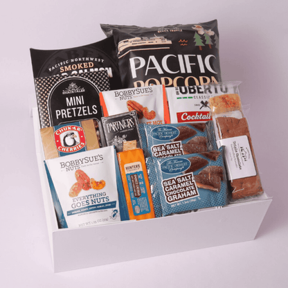 Elegant snack gift box wrapped in a navy blue satin bow, filled with Pacific Northwest treats like popcorn, chocolates, and gourmet snacks. Ideal for thank-you gifts, celebrations, and special occasions.