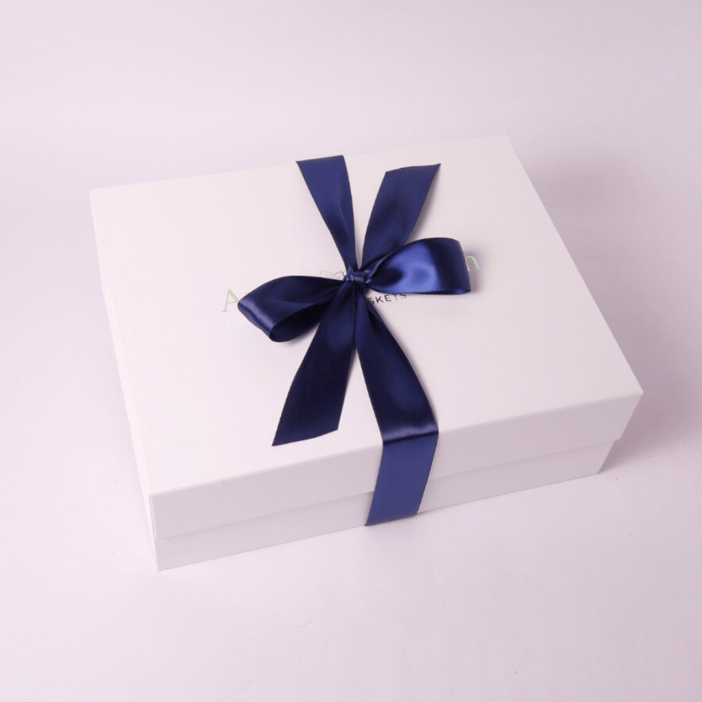 Minimalist snack gift box wrapped in a luxurious navy blue satin bow. A sophisticated and elegant gifting option for corporate, holiday, and appreciation gifts.