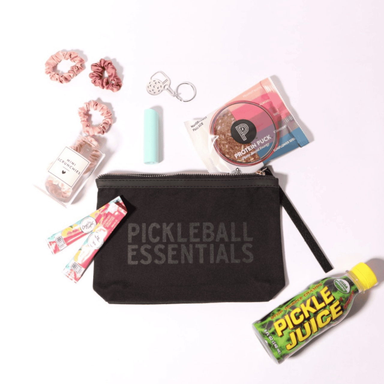 Pickleball Essentials Zipper Pouch, a stylish pickleball gift for her, featuring locally made in Washington accessories like a pickleball paddle keychain, energy bar, and lip balm. Perfect for any pickleball enthusiast!