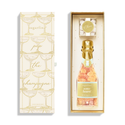 Champagne bottle-shaped Sugarfina gift set featuring champagne gummy bears and a cheers-themed box, viewed from above with the lid open.