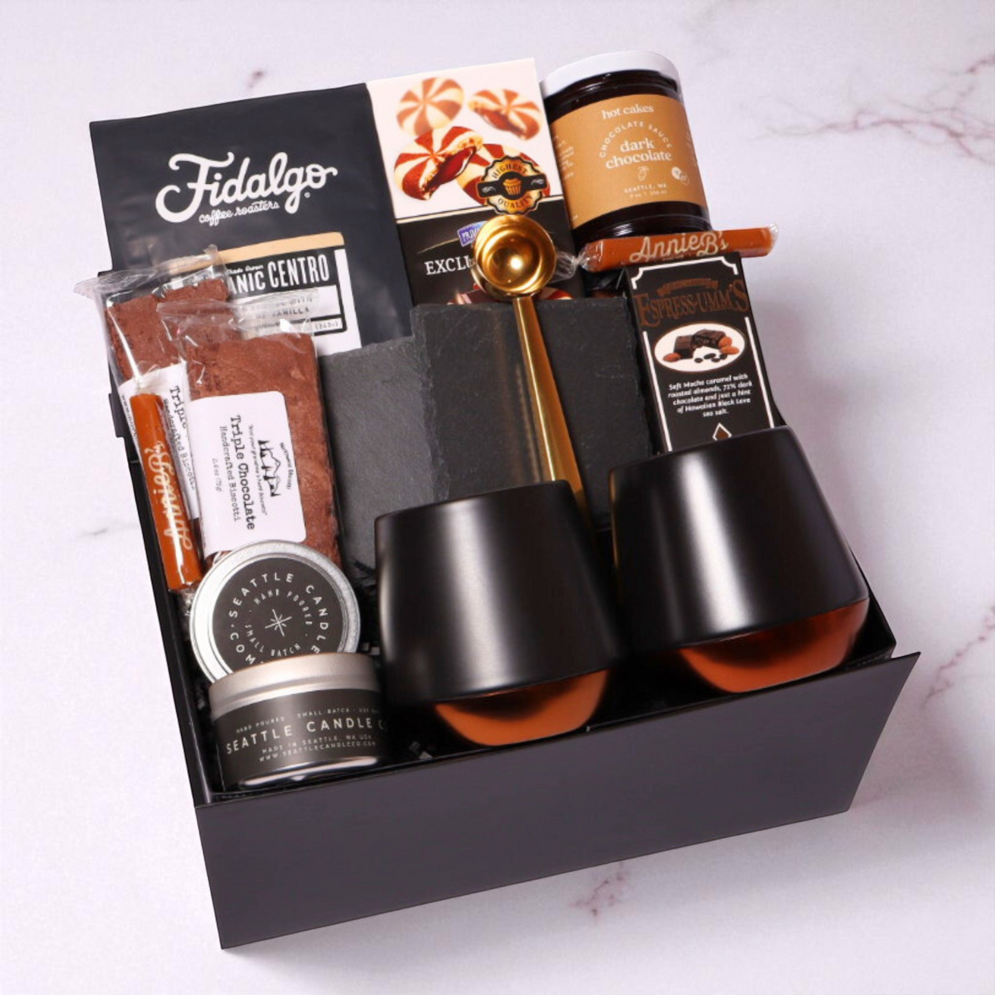 The Regal Coffee gift box in black signature packaging, filled with premium coffee essentials including double-walled ceramic mugs, Fidalgo organic coffee, and gourmet treats.