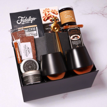 The Regal Coffee gift box in black signature packaging, filled with premium coffee essentials including double-walled ceramic mugs, Fidalgo organic coffee, and gourmet treats.
