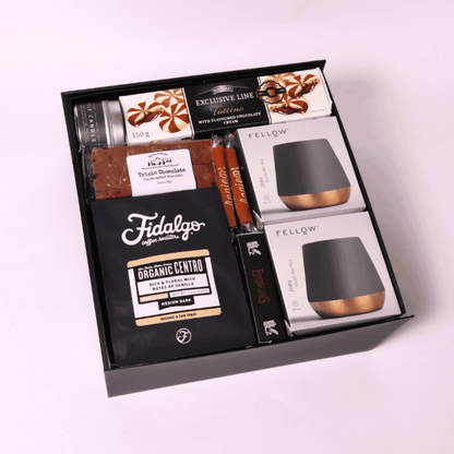 Elegant coffee gift set with ceramic mugs, espresso caramels, chocolate sauce, cookies, and a Coffee & Cream candle—ideal for coffee lovers.