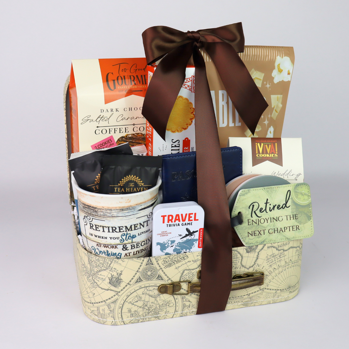 Retirement gift basket with travel themed goodies.  Basket includes travel snacks, retirement mug, stone coasters, and notebook all assembled in a decorative mini suitcase.