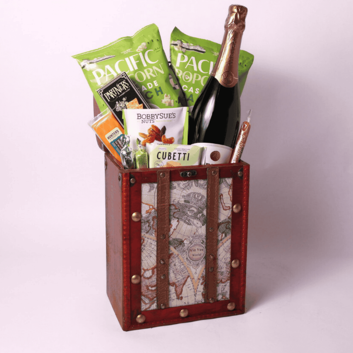 A travel-themed retirement gift for women, featuring popcorn, wafers, nuts, and sparkling spritz in a vintage-style chest. A perfect retirement gift for men or women who love gourmet snacks.