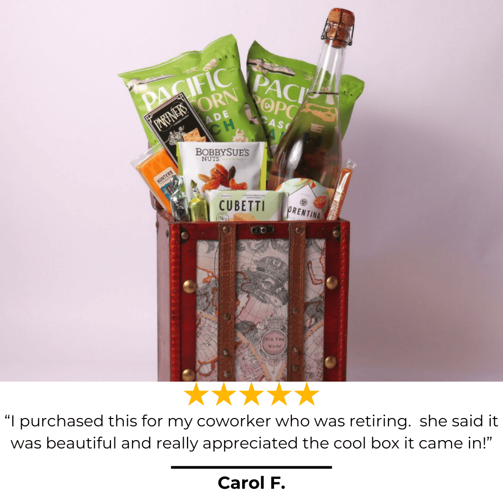 Flat lay of a retirement gift for women, featuring popcorn, wafers, nuts, and sparkling spritz in a vintage travel chest. A perfect retirement gift for men or women who love gourmet snacks.