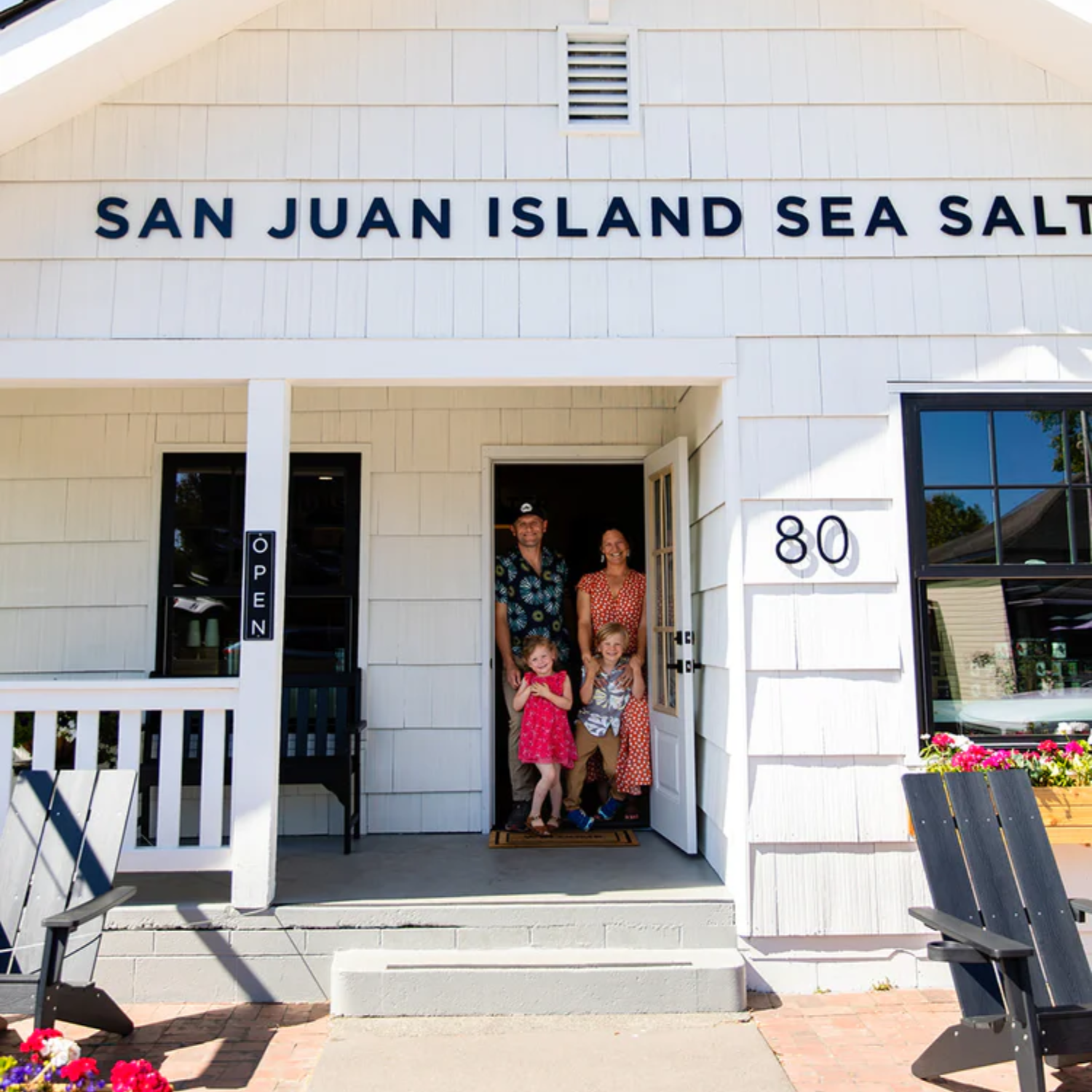 Family standing in front of a building with 'San Juan Island Sea Salt' sign