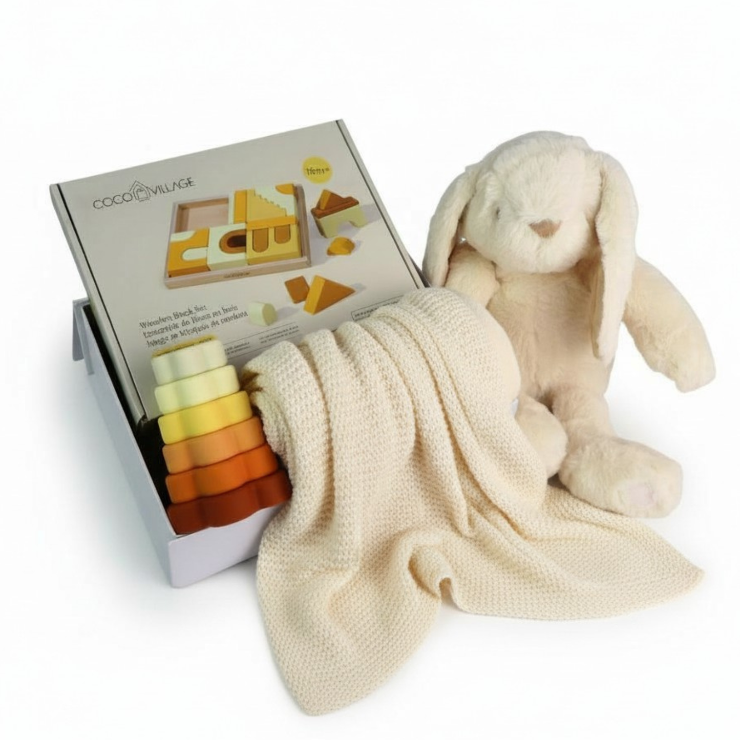 Baby gift set with plush toy, building blocks, and stacking rings on a white surface.