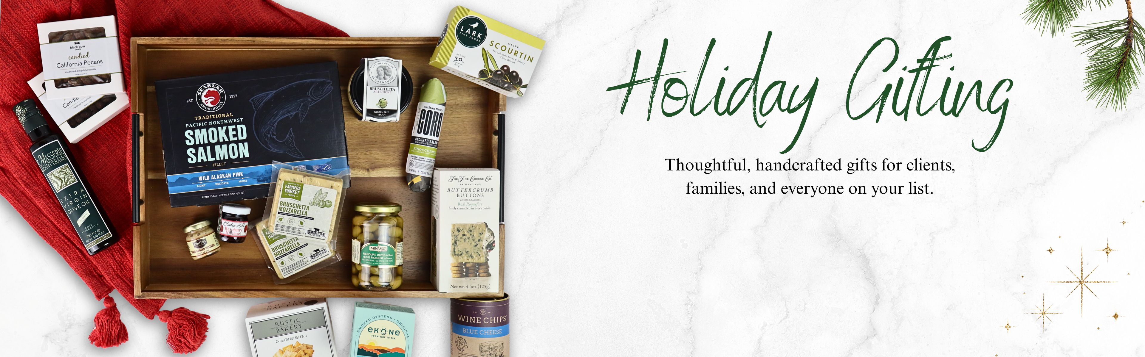 Luxury holiday gift basket filled with Washington-made snacks, smoked salmon, and gourmet treats on red linen — thoughtful corporate and family gifting from Apple Blossom Gift Baskets.