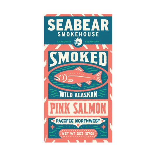 A rectangular package label or box front for Seabear Smokehouse smoked wild alaskan pink salmon, shown on a plain white background. The design uses teal, coral pink, cream, and dark blue with a fish illustration and the text 'Seabear Smokehouse,' 'Smoked,' 'Wild Alaskan,' and 'Pink Salmon.