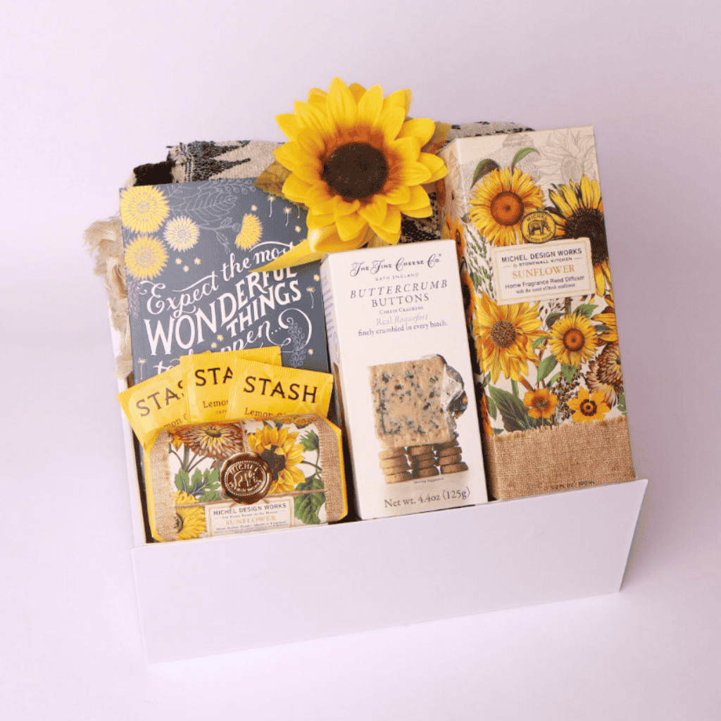 “Sunflower-themed gift box from a Seattle small business featuring cozy throw, tea, journal, soap, diffuser, and gourmet crackers—perfect for thoughtful gifting.”