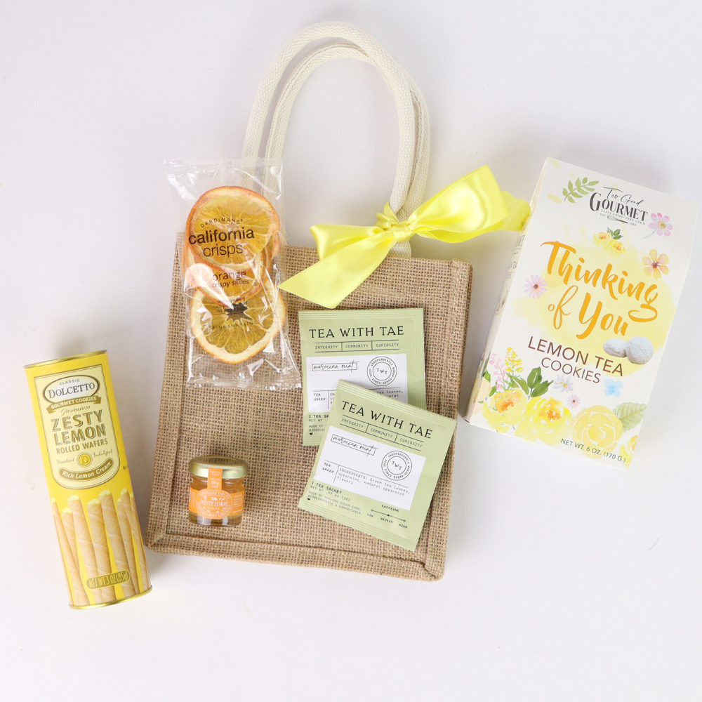 Seattle Thinking of You gift basket in jute tote with lemon tea cookies, tea sachets, honey, dried orange slices, and yellow bow